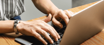 hands typing at a laptop
