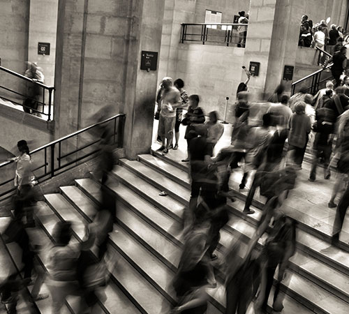 Black and white image of people walking up stairs
